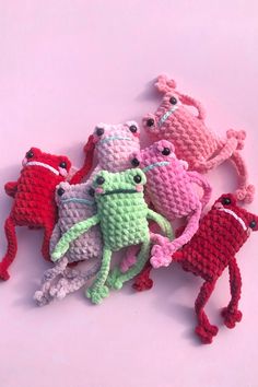 several crocheted stuffed animals sitting on top of each other in front of a pink background