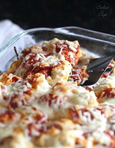 a close up of a pizza in a pan with a spatula on the side