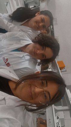 three women in lab coats standing next to each other