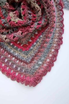 a multicolored crocheted shawl on a white background