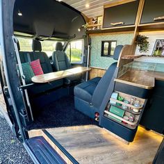 the interior of an rv with blue carpet and wooden tables in the back seat area