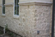 the corner of a building with a fire hydrant next to it and two windows