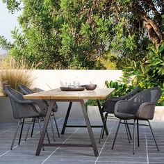 an outdoor dining table with chairs around it