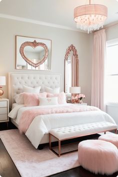 a white and pink bedroom with a large bed in the center, mirror on the wall