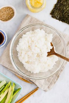 rice in a bowl with chopsticks and seasoning next to it