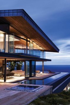 a modern house overlooking the ocean at dusk