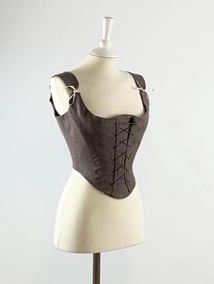 Experience opulence and grace with ISOLDE, our Renaissance Corset in Brown-Gray Linen. Meticulously handcrafted, this exquisite corset flatters your figure and provides unmatched comfort. Made from luxurious brown-gray linen, it exudes timeless elegance and versatility. The front lacing design and removable modesty panel ensure a flawless fit for any occasion. With its sturdy construction, this corset maintains its shape, ensuring you always look your best. Each handmade corset is unique, reflecting our commitment to craftsmanship. Peasant Bodice, 18th Century Dresses, Handmade Corset, Rococo Dress, Brown Corset, Popular Costumes, 18th Century Dress, Ren Fair, Modesty Panel