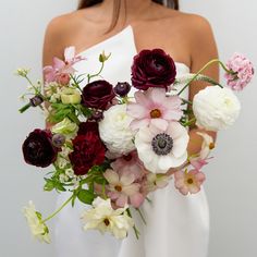 a woman holding a bouquet of flowers in her hands