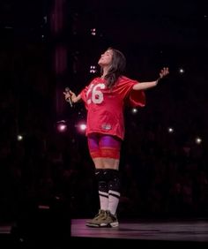 a woman in red jersey standing on stage