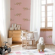 a baby's room with pink walls and white curtains