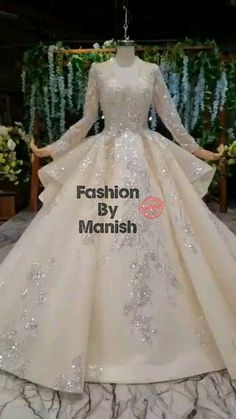 a white wedding dress with long sleeves and sequins on the skirt is displayed