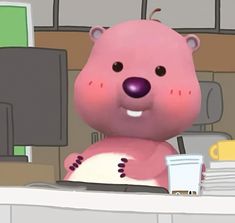 a pink bear sitting at a computer desk