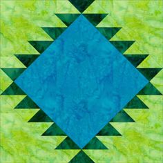 a green and blue quilt with an abstract design