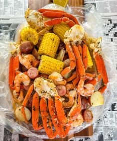 crab boil with corn on the cob, potatoes and carrots in plastic wrap