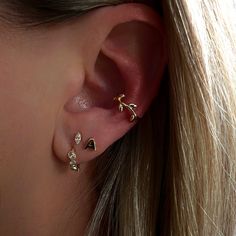 a close up of a person's ear with three different types of piercings