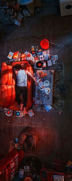 a man standing in the middle of a living room next to a red couch and coffee table