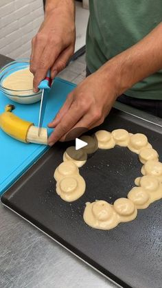 a man is decorating a cookie with icing and banana peels on a baking sheet