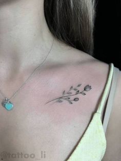 a woman's chest with a small blue heart on the left side of her neck