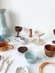 many different bowls and spoons on a table