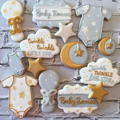 baby shower cookies are arranged on a brick wall with stars, moon and other decorations