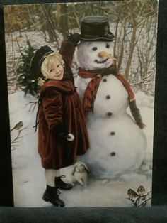 a child standing next to a snowman in the snow