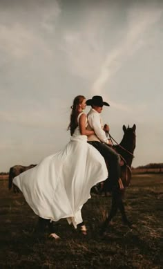 a bride and groom riding on the back of a horse