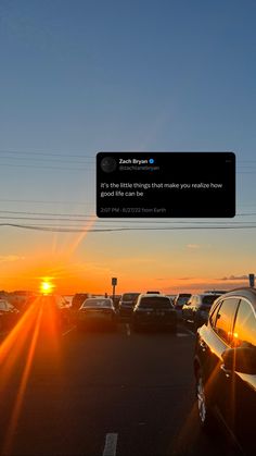 the sun is setting over a parking lot full of cars