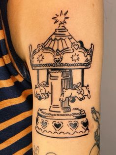 a woman with a tattoo on her arm has a small carousel in the shape of a heart