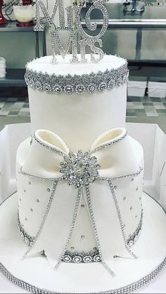 a white wedding cake with silver decorations on top