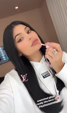 a woman with long black hair brushing her teeth