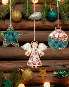 christmas ornaments hanging from a tree in front of a wooden wall with lights and garlands