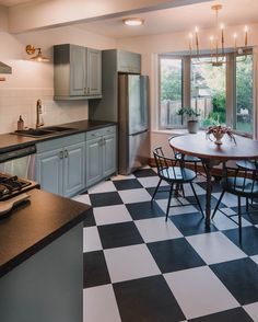 a kitchen with a checkered floor and black and white tile on the floor is shown