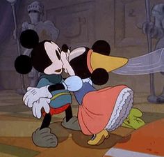 mickey and minnie kissing in front of a castle