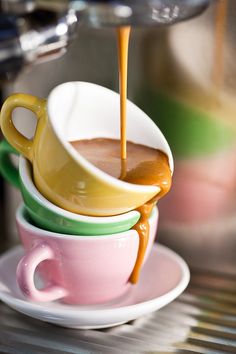 three cups filled with liquid sitting on top of each other