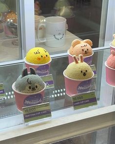 there are many different kinds of ice creams in the display case, including one with an animal face on it