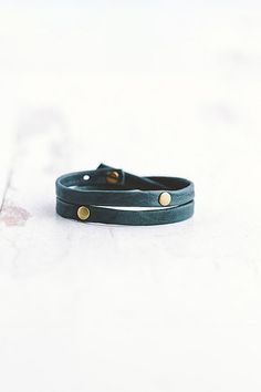 Made for the true warrior, our Double Warrior wrap is a narrow leather bracelet that wraps around the wrist twice and features two flat antique brass rivet accents. **Contents** * Lambskin leather, antique brass hardware * Button clasp closure * Handmade **Care/Import** * Made in the USA **Dimensions** * Adjustable to fit wrist sizes 6.5”-8” | Giving Bracelets Antique Brass Double Warrior Wrap Bracelet at Free People in Blue Blue Spruce, Antique Brass Hardware, Blue Bracelet, Brass Hardware, Lambskin Leather, Boho Outfits, Wrap Bracelet, Antique Brass, Leather Bracelet