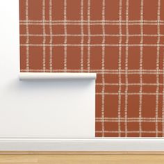 an orange and white plaid wallpaper next to a wooden floor