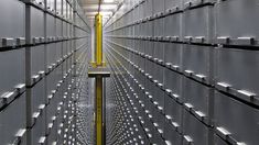 the inside of a large storage room with lots of metal boxes on each side and yellow poles in the middle