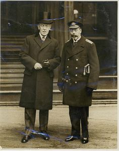 two men in coats and hats standing next to each other