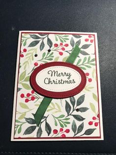 a christmas card with a red ribbon and green leaves on the bottom, in front of a black background