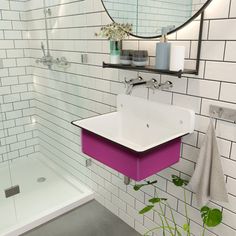 a bathroom with a sink, mirror and bathtub next to a plant in the corner