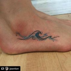 a small wave tattoo on the foot