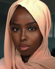 a woman wearing a headscarf and looking at the camera with an intense look on her face