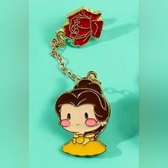 a cartoon character key chain with a flower on it's back end and a red rose in the background