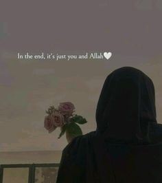 a person in a black hoodie holding a bouquet of flowers with the words in the end, it's just you and alih