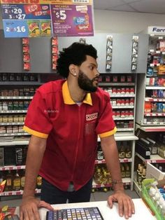 a man standing in front of a calculator at a grocery store with his hand on the counter