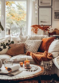 a living room filled with lots of pillows and blankets on top of a white couch