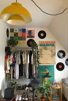 a room filled with lots of different types of clothes and decor on the wall next to a bed