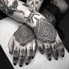 two hands with henna tattoos on them