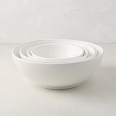 four white bowls stacked on top of each other